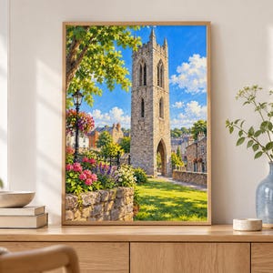 May include: A framed wall art print depicting a tall, weathered stone bell tower standing in a lush garden setting. The scene features a bright blue sky with white clouds, vibrant pink and yellow flowers, a black lamppost, and green trees.