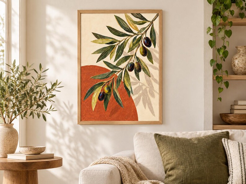 May include: A framed wall art print featuring a painted olive branch with green leaves and dark olives against a cream background. A large, solid terracotta-colored circle is positioned behind the branch, creating a layered, graphic composition.