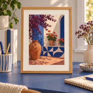 Pu&ograve; includere: Una stampa artistica incorniciata che raffigura una scena mediterranea con una grande anfora in terracotta, vivaci gerani rossi in vaso e piastrelle geometriche blu e bianche su una parete bianca, sotto una bouganville viola intenso.