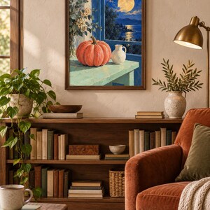 Pode incluir: Uma impress&atilde;o de arte de parede emoldurada retratando uma ab&oacute;bora laranja vibrante e um pequeno jarro branco sobre uma mesa verde clara. A cena mostra uma vista noturna de uma lua cheia sobre um mar azul escuro, emoldurada por uma janela.