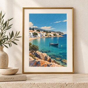 May include: A framed vertical art print depicting a coastal Mediterranean scene with white buildings, a small dark blue boat floating on clear turquoise water, and rocky foreground terrain under a bright blue sky with scattered white clouds.