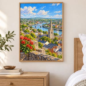 May include: A framed landscape painting depicting a town with a tall stone church spire, a river with a bridge, and lush green trees under a bright blue sky with white clouds. In the foreground, a stone wall is adorned with vibrant red flowers.