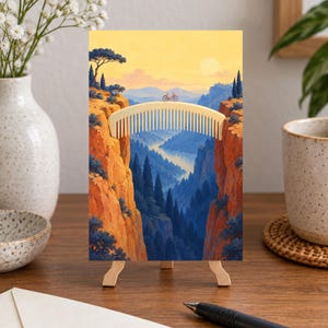May include: A rectangular art print featuring a surreal landscape where a light-colored hair comb serves as a bridge between two orange rocky cliffs. A small red bicycle sits on the comb, overlooking a deep valley with blue trees and a river.