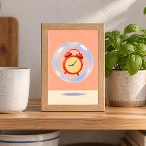 May include: A rectangular wooden frame containing a print of a red twin-bell alarm clock floating inside a transparent bubble against a solid peach-colored background. The clock features a round red face with blue hands and a small shadow below.