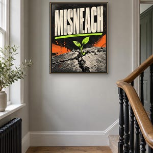 May include: A rectangular wall art print featuring the word MISNEACH in bold white capital letters above a bright green horizontal line. Below, a small green sprout emerges from a cracked, dark gray textured surface with orange accents.