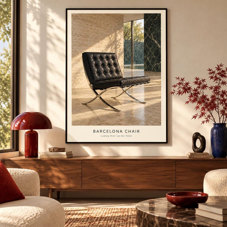 K&ouml;nnte beinhalten: Ein gerahmter Wandkunstdruck, der einen schwarzen, gesteppten Ledersessel mit Chromgestell zeigt, betitelt BARCELONA CHAIR von Ludwig Mies van der Rohe. Der Druck zeigt den Sessel in einem sonnendurchfluteten Raum mit einem schwarzen Rahmen.
