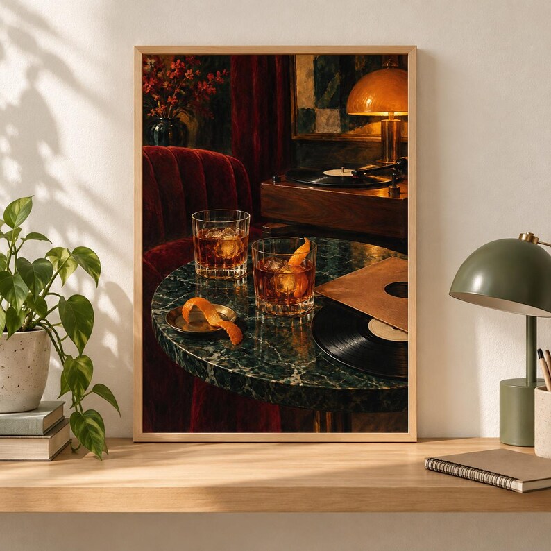 May include: A framed wall art print depicting a dark, moody interior scene with two crystal glasses filled with amber liquid and orange peels on a round green marble table. A black vinyl record, a record player, and a lamp are visible in the background.