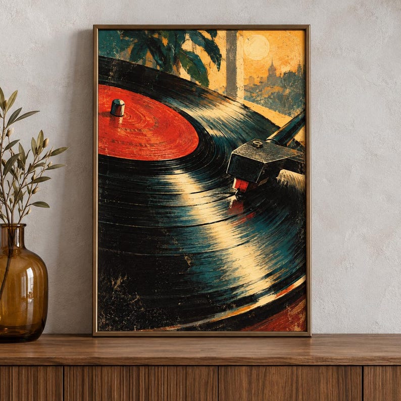 May include: A framed wall art print featuring a close-up of a black vinyl record on a turntable. The record has a bright red center label. The background depicts a stylized sunset scene with silhouettes of palm trees and buildings in warm tones.