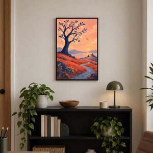 Op de afbeelding: Een ingelijste kunstdruk met een gestileerd landschap met een donkerblauwe boom die witte enveloppen als bladeren draagt. De sc&egrave;ne toont een kronkelend pad door rode heuvels dat naar een huis leidt onder een zachte oranje en roze zonsondergang.