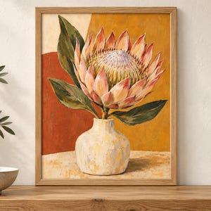 Pu&ograve; includere: Un dipinto incorniciato raffigurante un grande fiore di protea rosa e bianco con foglie verdi in un vaso testurizzato di colore chiaro. Lo sfondo presenta blocchi astratti di caldi colori ocra e terracotta, il tutto racchiuso in una cornice di legno.