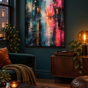 Puede incluir: Una pieza de arte mural rectangular enmarcada que presenta una pintura abstracta de paisaje urbano con trazos verticales vibrantes en rosa intenso, azul profundo y naranja, representando una calle lluviosa con reflejos de luces brillantes.