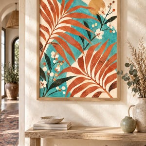 May include: A square wall art print in a light wood frame featuring a botanical illustration with large rust-colored palm leaves, white flowers, and dark green foliage set against a bright turquoise background with a golden circular sun element.