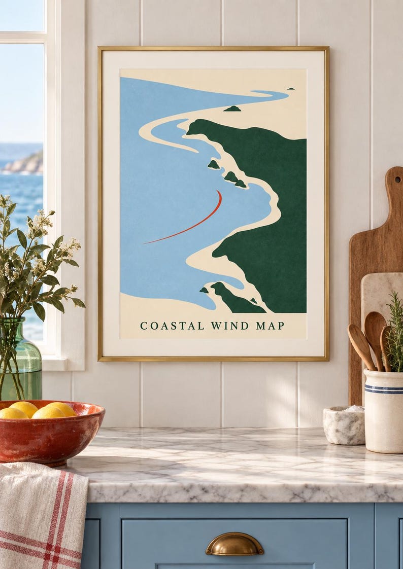 May include: A framed wall art print titled Coastal Wind Map featuring a minimalist graphic illustration of a coastline with dark green land, light blue water, a sandy beige shore, and a single curved red line indicating wind direction.