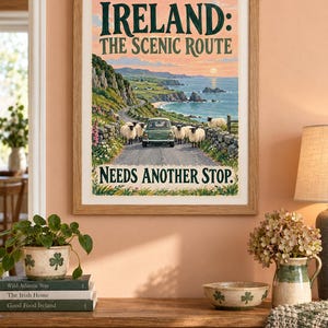 Puede incluir: Una l&aacute;mina art&iacute;stica enmarcada con una ilustraci&oacute;n paisaj&iacute;stica de la costa irlandesa, un coche verde en una carretera y ovejas. El texto dice IRELAND: THE SCENIC ROUTE y NEEDS ANOTHER STOP en letras de color verde oscuro sobre un cielo melocot&oacute;n.