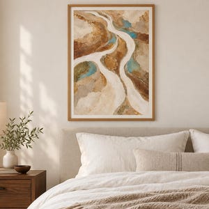 Pu&ograve; includere: Una stampa d'arte astratta incorniciata raffigurante un paesaggio fluviale nei toni del beige, marrone e marrone chiaro, con accenti di blu turchese. L'opera presenta forme organiche e fluide che ricordano un corso d'acqua tortuoso.