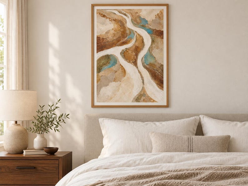 Pu&ograve; includere: Una stampa d'arte astratta incorniciata raffigurante un paesaggio fluviale nei toni del beige, marrone e marrone chiaro, con accenti di blu turchese. L'opera presenta forme organiche e fluide che ricordano un corso d'acqua tortuoso.