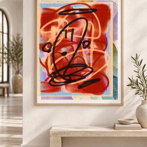 K&ouml;nnte beinhalten: Ein gerahmter abstrakter Wandkunstdruck mit kr&auml;ftigen, geschichteten Pinselstrichen in Dunkelrot, Hellblau und sanftem Orange. Die Komposition ist mit dicken, schwarzen, gestischen, tintenartigen Kritzeleien und Kreisformen &uuml;berlagert.