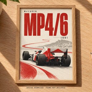 May include: A framed poster featuring a red and white McLaren MP4/6 Formula 1 race car from 1991. The artwork displays the car on a track with a red painted path, a mountain backdrop, and the bold red text McLaren MP4/6 1991 at the top.