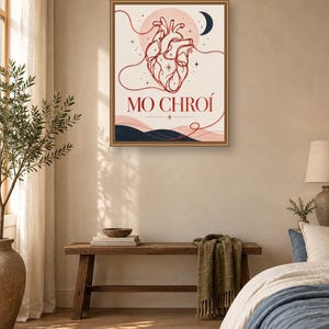 May include: A rectangular wall art print in a brown frame featuring a red line-art anatomical heart illustration, a dark blue crescent moon, and the text MO CHRO&Iacute; in red lettering, set against a cream background with dark blue abstract hills.