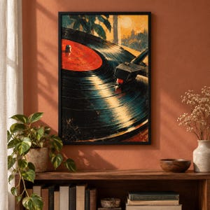 May include: A framed wall art print featuring a close-up illustration of a black vinyl record spinning on a turntable. The record has a bright red center label. The artwork uses warm yellow and orange tones in the background to depict a sunset scene.