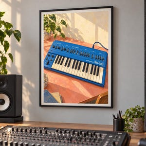 May include: A framed wall print featuring a blue Roland SH-101 synthesizer with white keys and black knobs. The synthesizer is positioned on a reddish-orange surface with a plant in the background, captured in warm, natural sunlight.