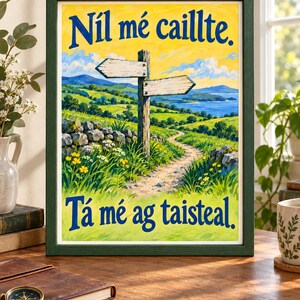 Op de afbeelding: Een ingelijste print met een landschapsschilderij van een zandpad, een houten wegwijzer en groene heuvels onder een gele lucht. De tekst "N&iacute;l m&eacute; caillte." staat bovenaan en "T&aacute; m&eacute; ag taisteal." onderaan in dikke blauwe letters.