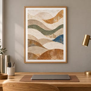 Pu&ograve; includere: Una stampa artistica incorniciata che presenta una serie di onde orizzontali stratificate e ondulate in tonalit&agrave; terracotta, beige, verde salvia e un accento blu intenso, il tutto in una semplice cornice in legno chiaro su una parete neutra.