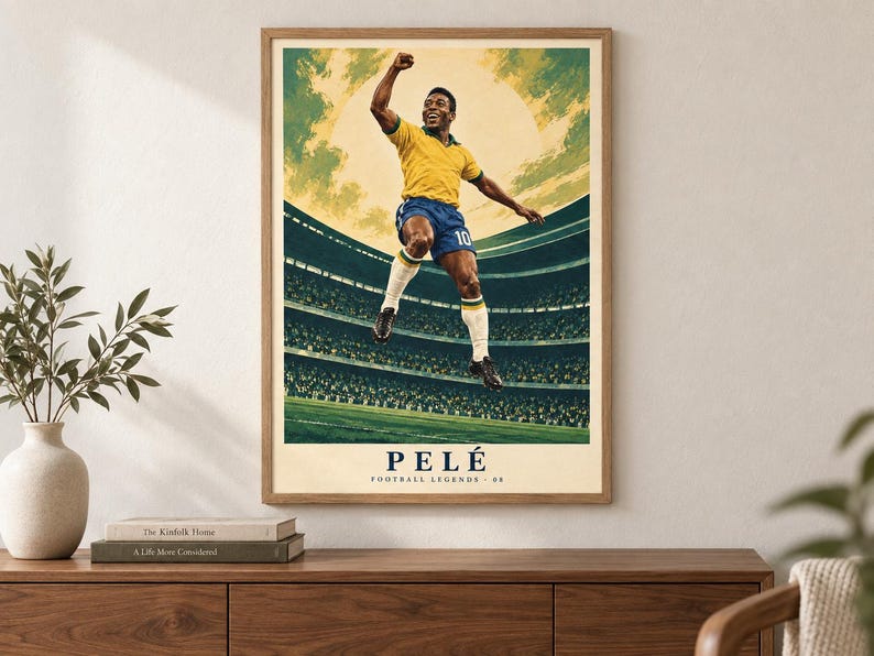 Pode incluir: Um cartaz vertical emoldurado com uma ilustra&ccedil;&atilde;o estilizada de um jogador de futebol com camisola amarela e cal&ccedil;&otilde;es azuis a saltar em celebra&ccedil;&atilde;o. O fundo mostra um est&aacute;dio com um grande sol. O texto PEL&Eacute; FOOTBALL LEGENDS 08 encontra-se na parte inferior.