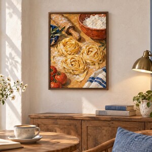 May include: A framed wall art print depicting a culinary scene with three nests of fresh yellow pasta, a wooden rolling pin, a bowl of white flour, three red tomatoes, and a blue and white striped cloth on a wooden surface dusted with flour.