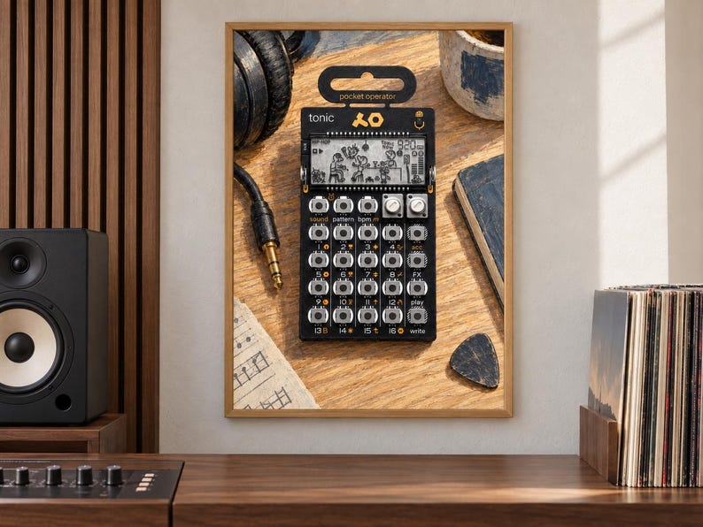 May include: A black Teenage Engineering PO-32 Tonic pocket operator synthesizer featuring a monochrome LCD screen with animated graphics, a grid of sixteen silver buttons, two rotary knobs, and the text "tonic" and "pocket operator" printed on the front.