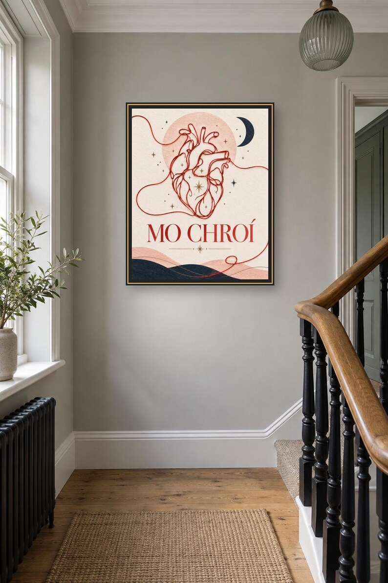 May include: A framed wall art print featuring a red line-art anatomical heart centered against a pale background with a crescent moon, stars, and dark blue hills at the bottom. The text MO CHRO&Iacute; is printed in red below the heart illustration.