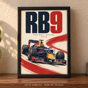 May include: A framed poster featuring a dark blue and red Formula 1 race car on a track. The text RB9 is displayed in large blue and red letters at the top, with Red Bull Racing 2013 printed below. A red brushstroke graphic curves across the background.