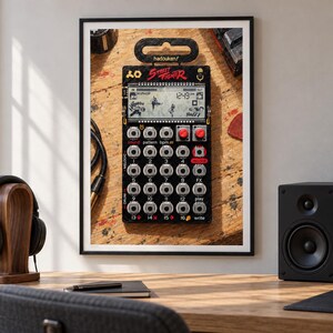 May include: A black Street Fighter themed pocket synthesiser featuring a digital display, sixteen numbered buttons, two red knobs, and a top hanging tab. The device displays the text hadouken and Street Fighter on its front panel.
