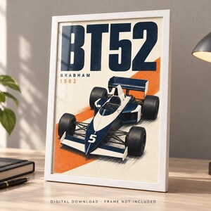 May include: A framed poster featuring a dark blue and white Brabham BT52 Formula One race car with the number 5 on the nose. The text BT52, BRABHAM, and 1983 are printed in dark blue and orange above the car, set against a cream background.
