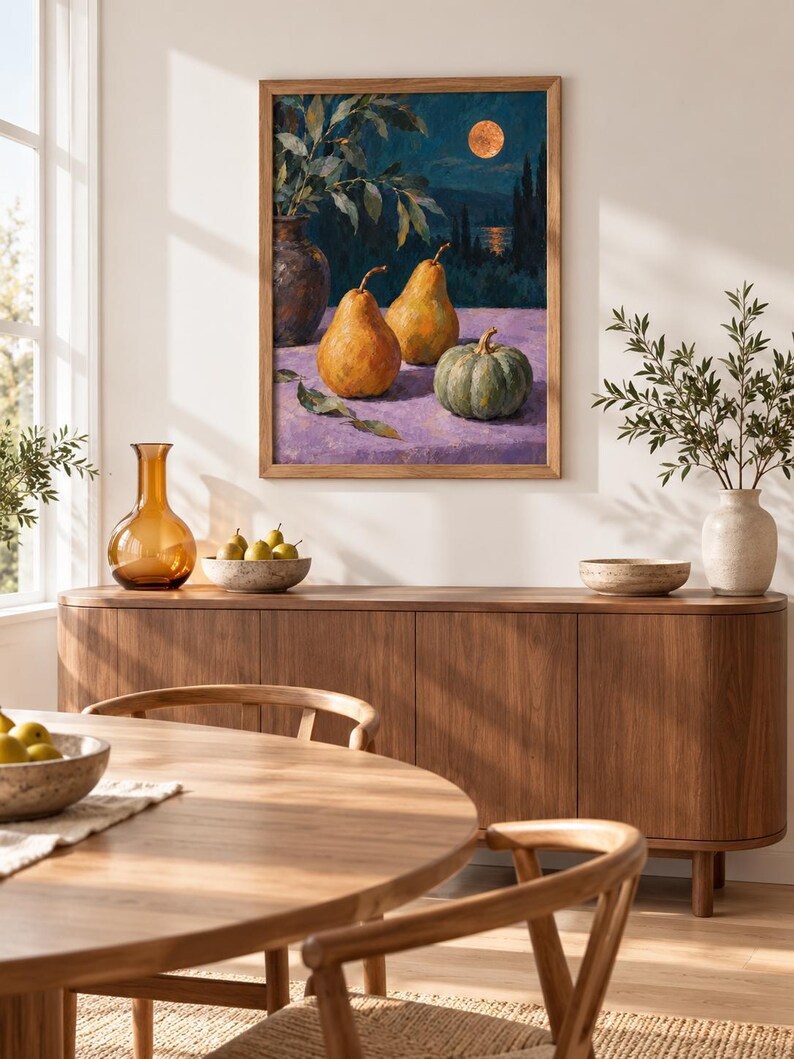 May include: A framed oil painting depicting a still life with two yellow pears and a green pumpkin on a purple surface, set against a dark blue night landscape with a full moon, displayed on a wall above a wooden sideboard with decor items.
