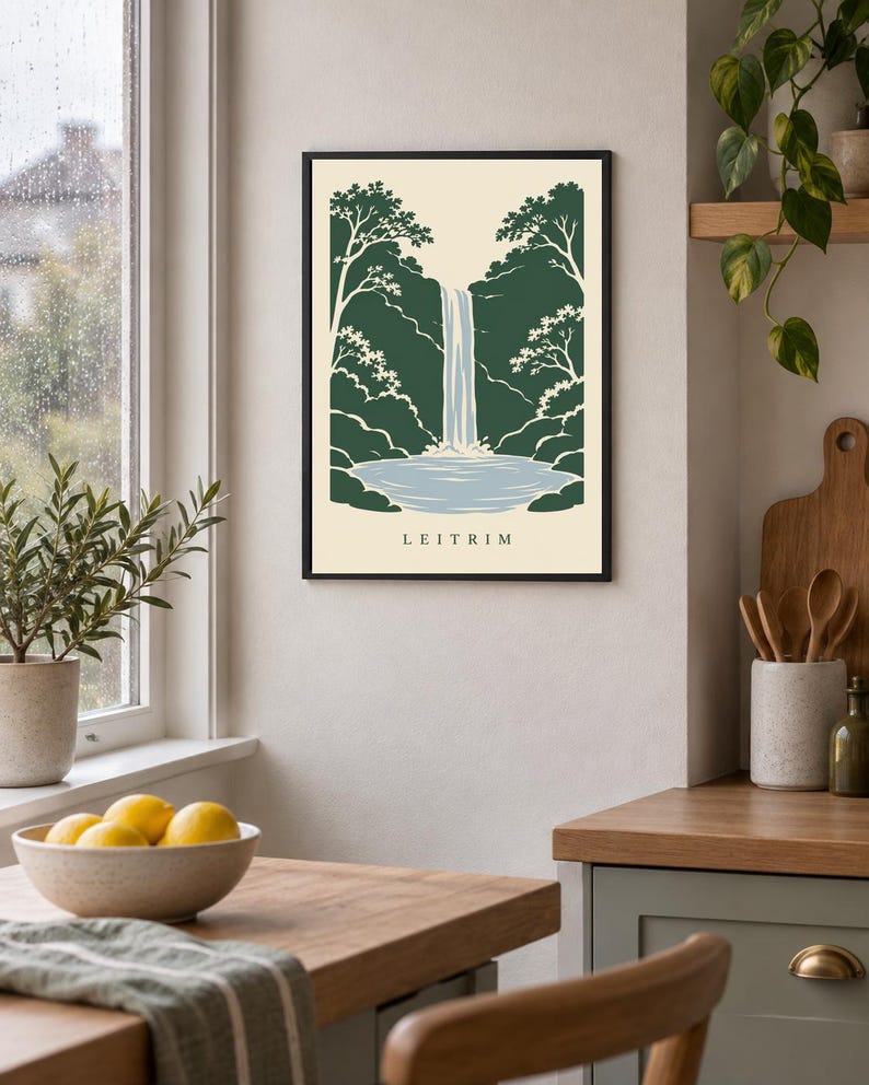 K&ouml;nnte beinhalten: Ein gerahmter Wandkunstdruck mit einer stilisierten Illustration eines Wasserfalls, der in ein Becken st&uuml;rzt, umgeben von dunkelgr&uuml;nen B&auml;umen und Laub. Der Hintergrund ist cremefarben und das Wort LEITRIM ist unten in Schwarz gedruckt.
