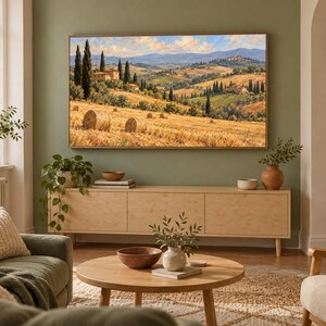 May include: A rectangular wall art print featuring a landscape painting of a Tuscan countryside with golden hay bales in the foreground, cypress trees, rolling hills, and a stone villa under a blue sky with soft clouds, framed in a light wood frame.