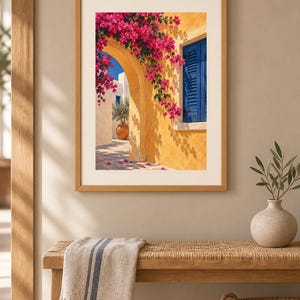 May include: A framed wall art print depicting a Mediterranean scene with a yellow stucco archway, vibrant pink bougainvillea flowers, a bright blue shuttered window, and a terracotta pot containing a small tree on a stone patio.