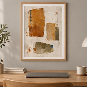 May include: A framed abstract wall art print featuring three distinct rectangular shapes in shades of burnt orange, muted olive green, and tan against a textured off-white background with subtle splatters of rust-coloured paint.