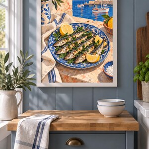 May include: A framed wall art print depicting a Mediterranean coastal scene with a blue and white patterned plate holding grilled fish garnished with fresh parsley and lemon wedges, set against a backdrop of a harbour with boats and white buildings.