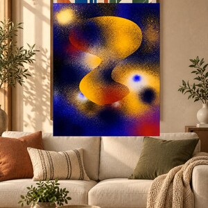 May include: A rectangular wall art print featuring an abstract spray paint design with a central, organic yellow and orange shape set against a deep blue background. The composition includes scattered yellow and white speckles and glowing orbs.