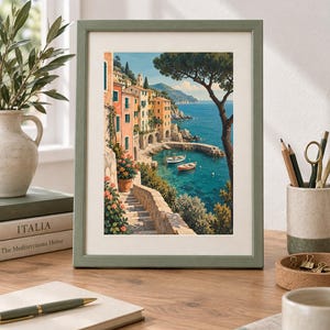 May include: A framed art print featuring a coastal scene with colourful buildings, stone stairs, and two small boats floating in clear blue water. The artwork is displayed in a sage green frame with a white mat, capturing a Mediterranean landscape.