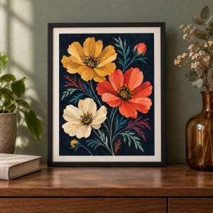 May include: A framed wall art print featuring a botanical illustration of three large cosmos flowers in yellow, orange, and cream against a dark navy blue background, accented with dark green and reddish foliage and a small flower bud.