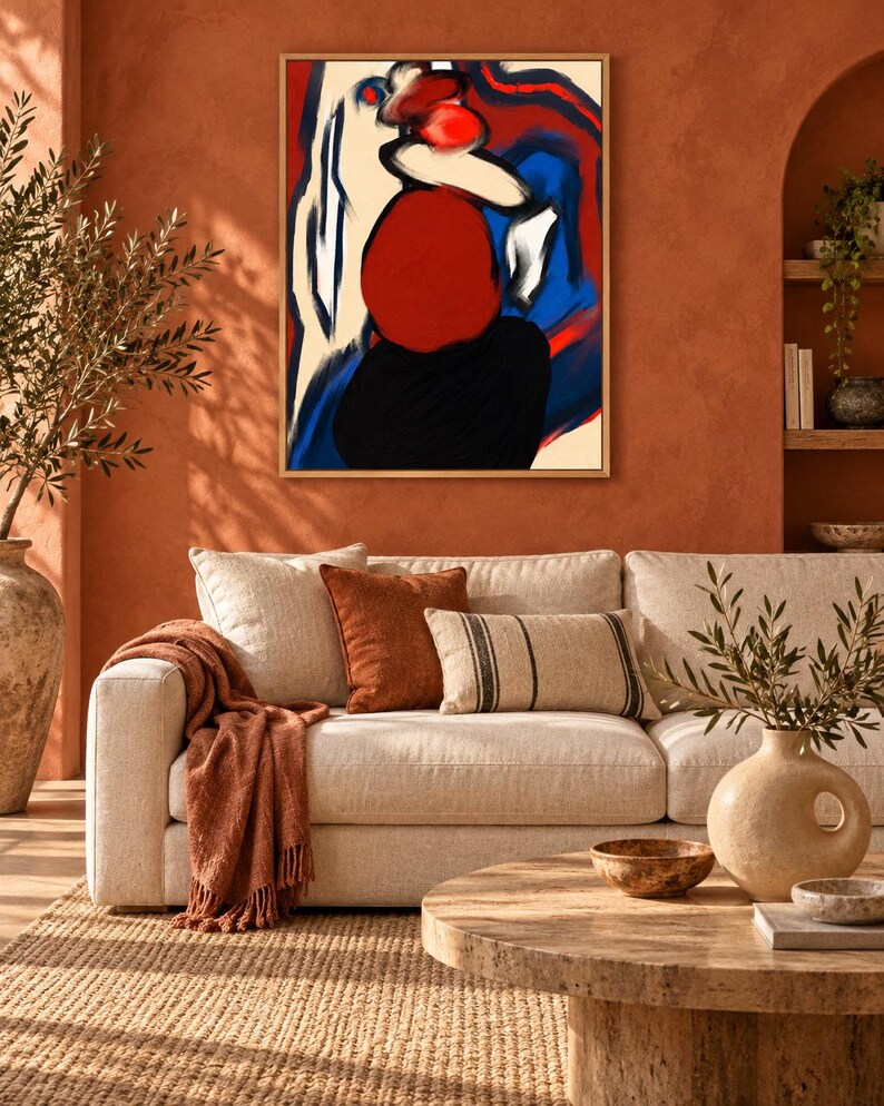 May include: A framed abstract wall art piece featuring bold, expressive brushstrokes in vibrant red, deep blue, black, and cream tones. The composition displays a central red circular form set against contrasting dark and light color blocks.