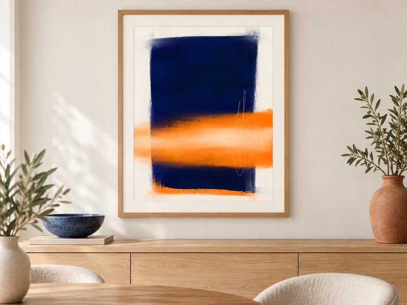 K&ouml;nnte beinhalten: Ein gerahmter abstrakter Wandkunstdruck mit einem gro&szlig;en, vertikalen, dunkel marineblauen rechteckigen Block, der von einem horizontalen, weichkantigen orangefarbenen Band &uuml;berlagert wird. D&uuml;nne, wei&szlig;e, handgezeichnete Linien sind sichtbar.