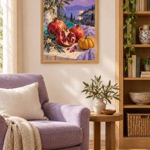 Op de afbeelding: Een ingelijste kunstdruk met een stilleven van granaatappels, een kleine pompoen en witte bloemen op een stenen richel, tegen een achtergrond van een kustlandschap met een volle maan boven een kalme zee en verre heuvels.
