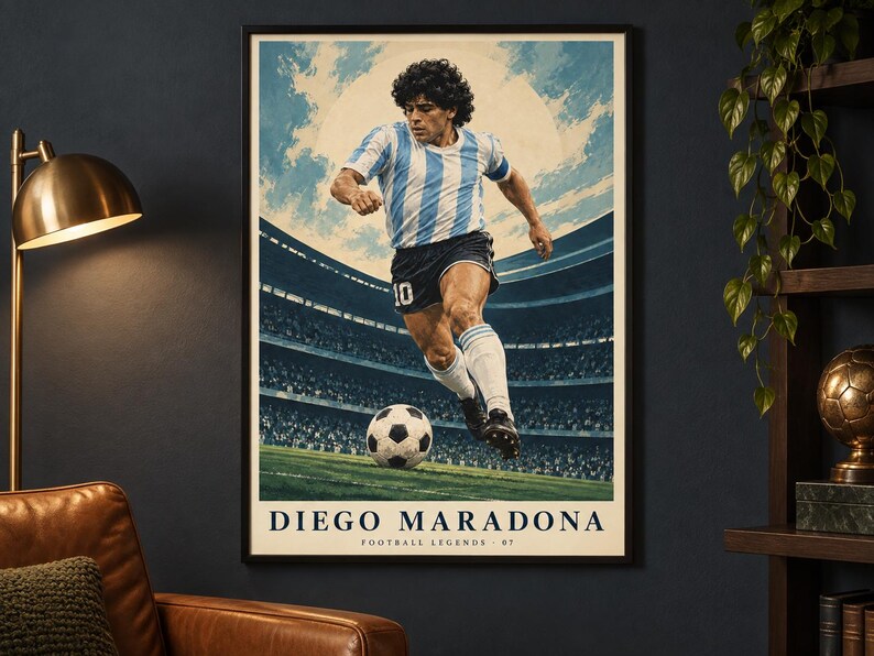 K&ouml;nnte beinhalten: Ein gerahmtes vertikales Poster mit einer stilisierten Illustration eines Fu&szlig;ballspielers in einem hellblau-wei&szlig; gestreiften Trikot und schwarzen Shorts, der einen Fu&szlig;ball auf einem Spielfeld tritt. Der Text DIEGO MARADONA FOOTBALL LEGENDS 07 steht unten.