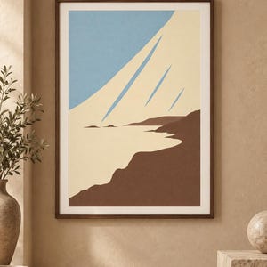 May include: A framed wall art print featuring a stylized landscape with a light blue sky, a cream-colored expanse, and dark brown landforms. The composition uses clean, flat shapes to depict a coastal scene with sharp, diagonal blue lines.