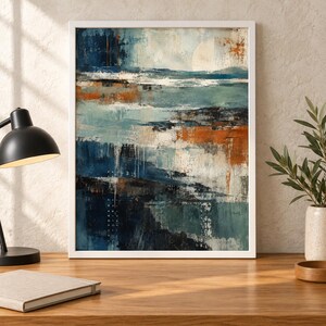 Op de afbeelding: Een ingelijst abstract schilderij met gelaagde horizontale streken in diep marineblauw, talingblauw en gebrand oranje. De compositie bevat getextureerde witte accenten en een bleke cirkelvorm aan de bovenzijde, gevat in een eenvoudige witte lijst.