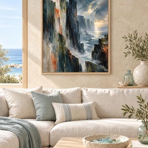 May include: A framed wall art print depicting a dramatic coastal landscape with steep, dark cliffs, crashing ocean waves, and a bright horizon. The painting features a palette of deep blues, grays, and earthy orange tones with visible brushstrokes.